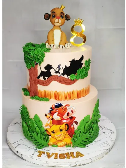 A grand Lion King themed two-tier cake for Tvisha's 8th birthday. This choco-vanilla cake features a handmade fondant Simba on top and beautiful silhouette details from the movie.