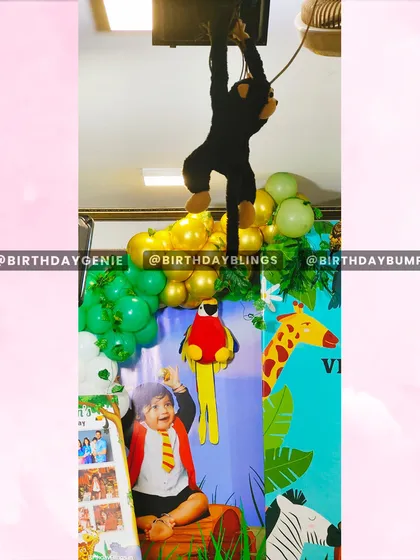 The hanging monkey prop adds a playful, dynamic element to the top of the jungle-themed backdrop.