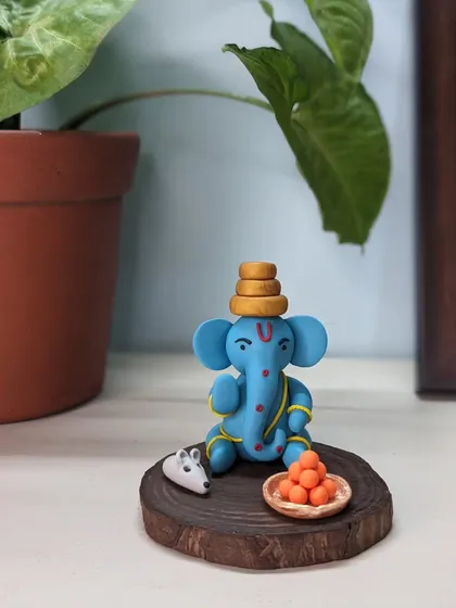 A small idol with a big presence. This blue Ganesha, complete with his mushak and laddoos, brings the entire feeling of a puja corner to your desk or shelf.