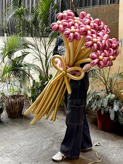 A gift that truly makes a statement. This gigantic balloon flower bouquet, with its golden stems and vibrant pink blossoms, is designed to wow. It's a unique and long-lasting alternative to traditional flowers, perfect for making any occasion unforgettable.