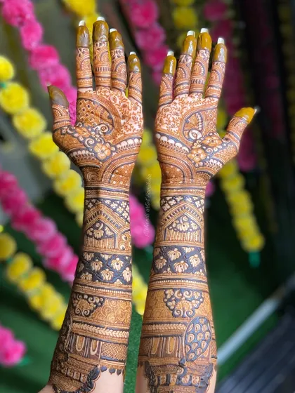 This bridal mehendi, set against a festive background, features peacocks and intricate patterns. The full coverage design is perfect for a grand wedding celebration.