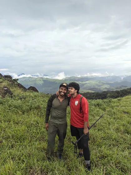 Two trek mates, one with his arm around the other, smiling in a grassy meadow. This image perfectly captures the friendship and support found on our trips.