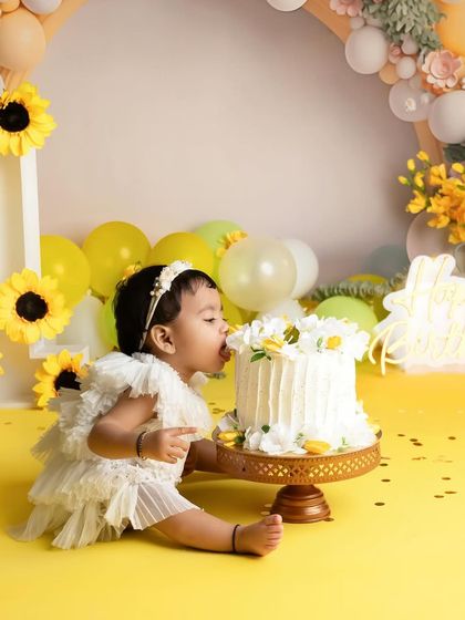 A close up of the birthday girl getting her first taste of cake. The details in this sunflower themed cake smash, from the cake to the decor, are all planned to create a beautiful scene.