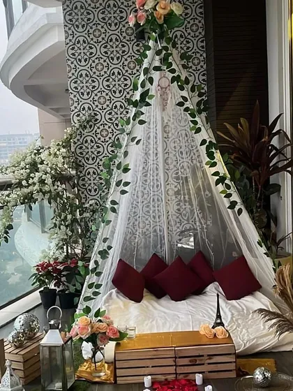 A daytime view of our charming teepee cabana on a balcony. Decorated with faux ivy and flowers, this setup provides a lovely, intimate space for a daytime proposal or a romantic brunch.