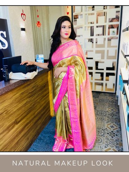 The rich colors of the saree are beautifully enhanced by the makeup, which features a classic red lip and defined, elegant eyes.