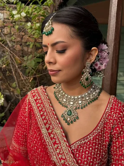 A side profile of the bride, showcasing the soft smokey eyes and the beautiful floral hair accessory. This highlights how every detail, from makeup to hair, comes together to create a cohesive bridal look.