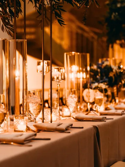 The right ambiance sets the tone for connection and conversation. This image showcases an elegant tablescape with warm, ambient candle lighting and luxurious settings, a signature of the sophisticated atmosphere I create for my clients.