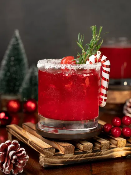 A festive Christmas cocktail. The deep red color, candy cane garnish, and snowy rim make this the perfect holiday drink.
