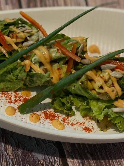 Fresh lettuce wraps filled with a savory mixture and topped with sunflower seeds and a creamy dressing. A light, healthy, and crunchy appetizer option.
