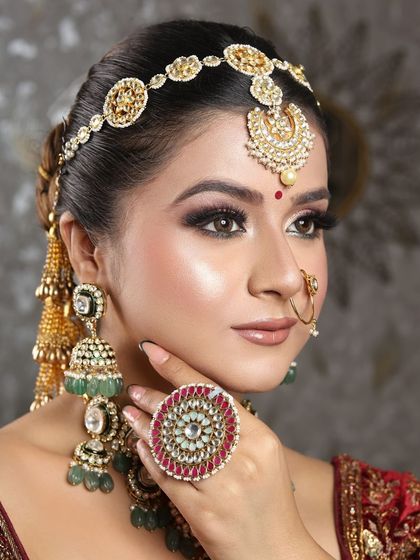 A side view of the bride, showing off her intricate hairstyle and the stunning ring that completes her look. The makeup is flawless from every angle.