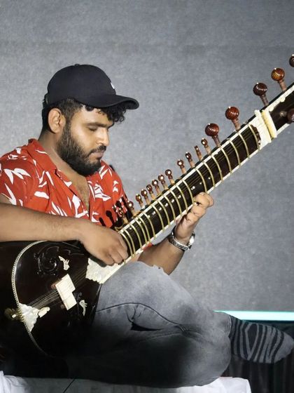 A focused shot during a fusion concert. Even when playing with a band, the core techniques of sitar playing remain the same.