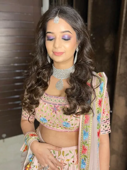 This close-up really highlights the beautiful purple tones on her eyes, a perfect choice for a modern and stylish wedding guest.