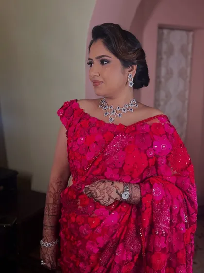 The client looking absolutely stunning in her pink floral saree, her hair styled in a glamorous updo.