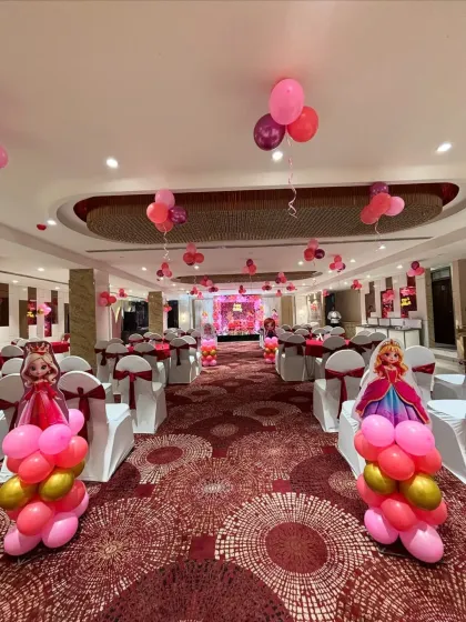 We can transform any banquet hall into a princess ballroom. This image shows the full room setup with themed aisle markers and coordinated chair sashes.