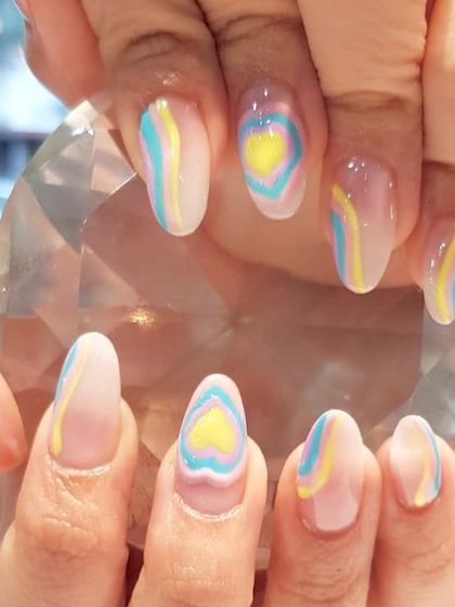 A dreamy pastel heart design. This look features a soft, abstract heart shape created with layers of pastel blue and yellow for a subtle and artistic manicure.