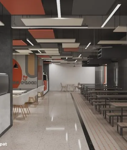 The cafeteria at Rishihood University, Sonipat, features an industrial aesthetic with exposed ceilings and a mix of seating types. The design creates a dynamic and functional dining space for students and faculty.