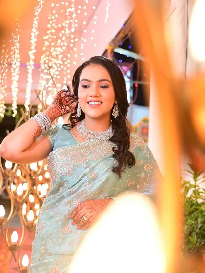A creative shot through the decor, capturing her happy expression and sparkling jewelry.