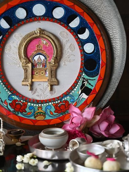 The Chandra (Moon) frame, set amidst a serene arrangement of silver and jasmine. The painting on the frame depicts the waxing and waning phases of the moon, reflecting its fickle and ever-shifting nature as described in Vedic texts.
