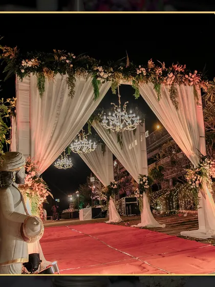 The entrance to the wedding ceremony was grand and regal, with a red carpet, draped archways, and stunning chandeliers.