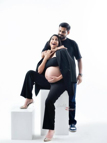 A fun and candid moment between a couple during their modern studio shoot. Dressed in matching black outfits, their playful interaction makes for a memorable and authentic portrait.