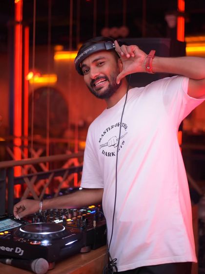 A shot of me with my headphones on, hand on the deck, ready to mix. This captures my focus and passion for the craft.