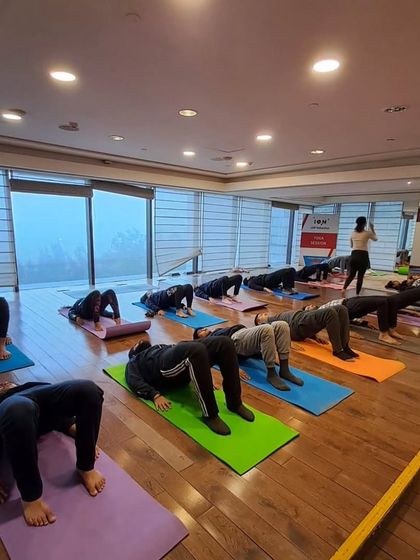 Embracing the power of balance and mindfulness in the corporate world. Here, a group of employees starts their day with a gentle bridge pose to open up the body.