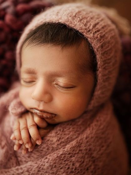 A slightly wider shot of the same baby, showing their peaceful expression and tiny hands.