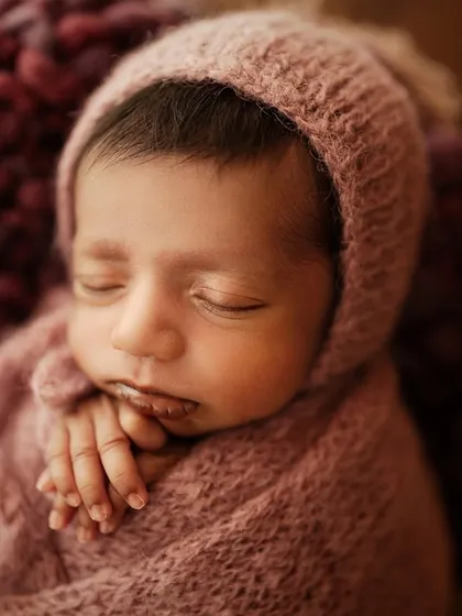 A slightly wider shot of the same baby, showing their peaceful expression and tiny hands.