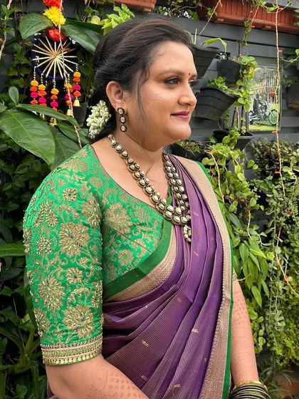 A portrait of the client in her green and purple outfit, looking elegant and ready for a celebration.