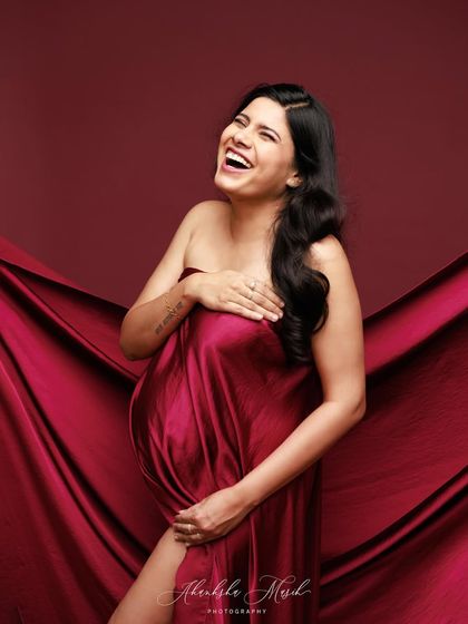A moment of pure joy and laughter, captured while draped in luxurious red satin. It shows that these sessions are fun and relaxed.