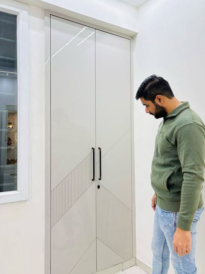 A minimalist wardrobe design with a grooved pattern and sleek black handles, perfect for a modern bedroom.