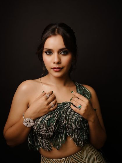 A full view of this emerald green cocktail look. The dramatic eye makeup is balanced with a flawless base and a nude lip, letting the eyes be the star of the show.