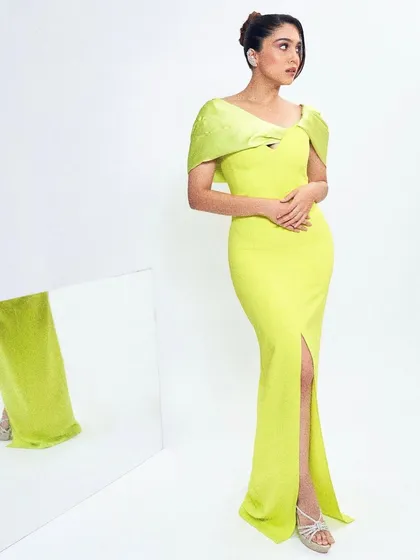 This lime green gown by Safiyaa is all about modern elegance. The structured shoulder detail and thigh-high slit create a look that is both sophisticated and edgy.