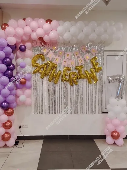 A pastel balloon frame with a silver fringe backdrop for a 7th birthday party.