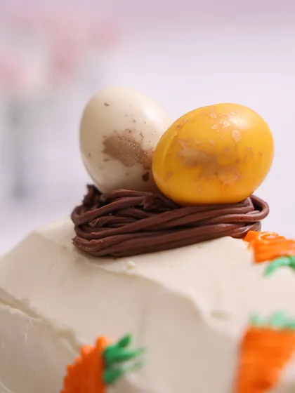 A close-up of the carrot roll cake's topping: a miniature chocolate nest with two speckled eggs.