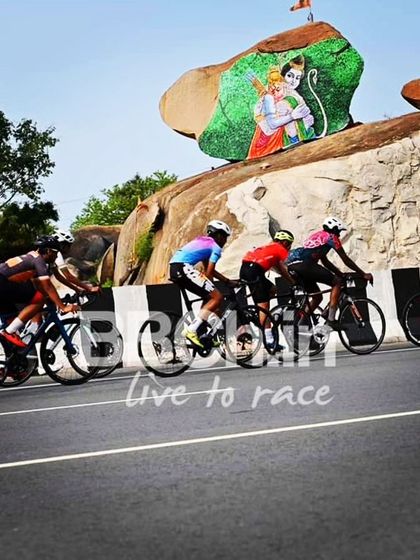 The peloton passes a colorful mural on a rock face, a unique feature of the race route.