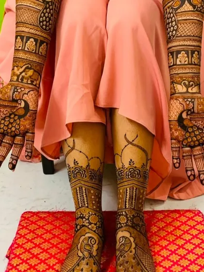 A close-up of the matching hand and feet mehndi. The design features peacocks and elephants, classic symbols of beauty and good fortune.