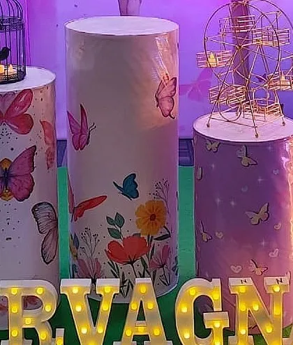 Themed pedestals and props for the butterfly fairy party, including a mini Ferris wheel and birdcage.