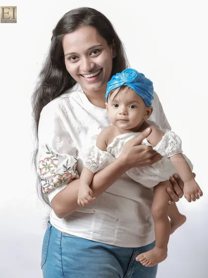 A mother proudly holds her baby, who is looking right at the camera. We capture both posed and candid moments to give you a variety of beautiful family photos.