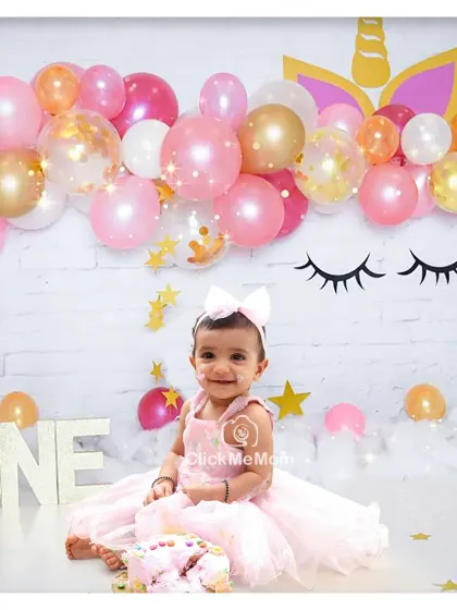 A magical unicorn-themed first birthday celebration. The balloon arch and fluffy clouds create a dreamy setting for this little one's special day.