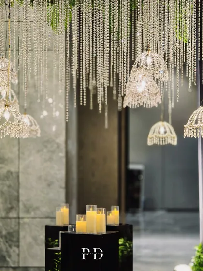 A close-up of the crystal-themed entrance, focusing on the warm glow of the candles against the sparkling chandeliers. The contrast creates a welcoming and luxurious feel.