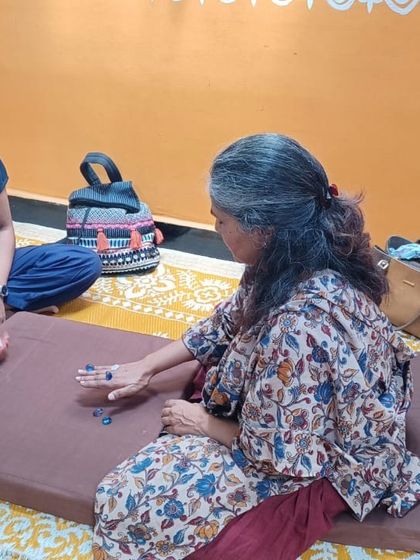 Two participants enjoying a game of Five Stones, exploring how traditional play can become a tool for experiential learning.
