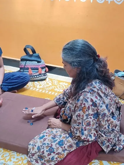 Two participants enjoying a game of Five Stones, exploring how traditional play can become a tool for experiential learning.