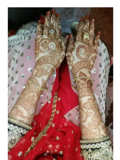 A beautiful photo of a bride's hands after the henna has fully matured. The intricate details are still sharp and clear in the dark stain.