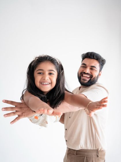 A father playing "airplane" with his daughter. These playful moments create the best memories.