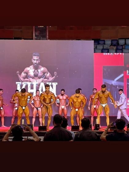 The stage is where all the hard work is judged. Here you can see a large lineup of competitors, and my athletes are right there in the center, holding their own. We prepare to compete against the best in the bodybuilding circuit.