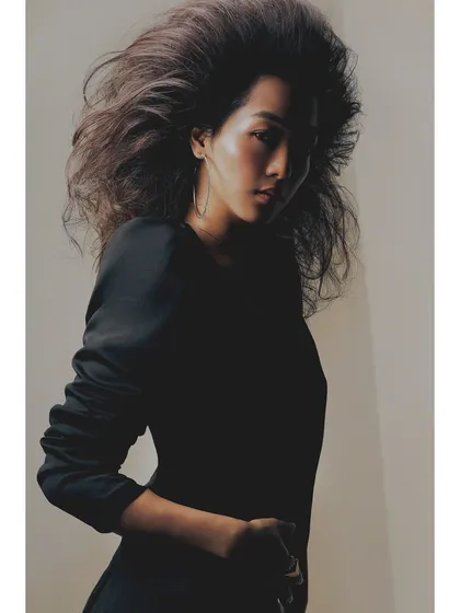A moody portrait from the 'Patricia' series. The play of shadow across the model's face adds a layer of mystery and depth, while still highlighting the incredible volume of the hair.