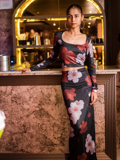 A stylish guest posing by the bar in a floral two-piece outfit.