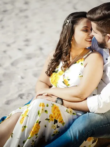 A close-up, happy moment from a beach pre-wedding shoot, showing the couple's genuine smiles.