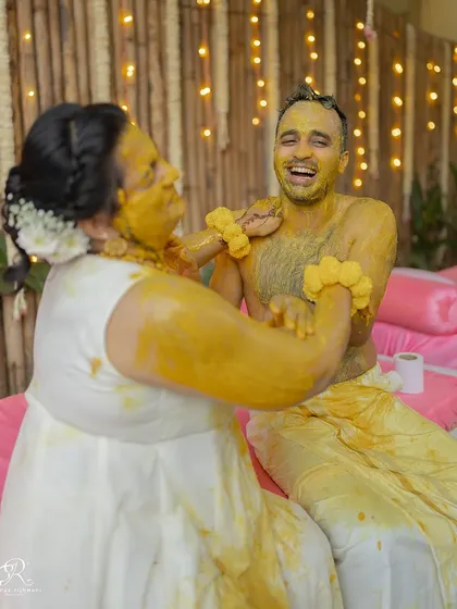 A candid moment of laughter between the couple during their very messy and joyful Haldi ceremony.